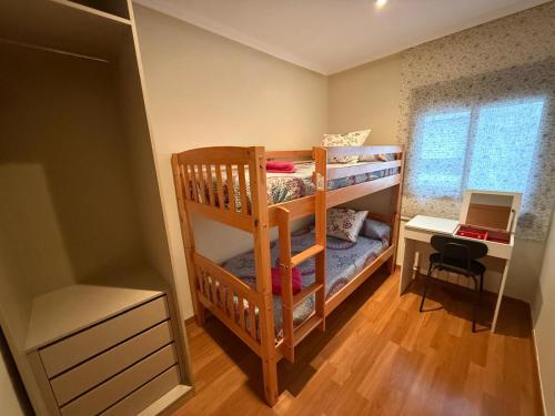 a bedroom with two bunk beds and a desk at Cozy apartment for 7 people - Port Aventura in Vila-seca