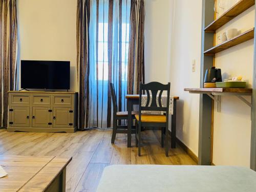 a room with a table and a chair and a television at Frühstückspension Das Einser in Heiligenkreuz