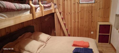 a bedroom with two bunk beds and a chair at LES LAIX - Chaleureux appartement 5 pers - Proche La Rosière in Montvalezan