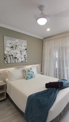 a bedroom with a large white bed with a window at Lodge Azure in Port Edward