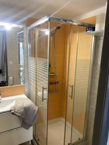 une douche avec une porte vitrée dans une salle de bain dans l'établissement Maison, à Port-la-Nouvelle