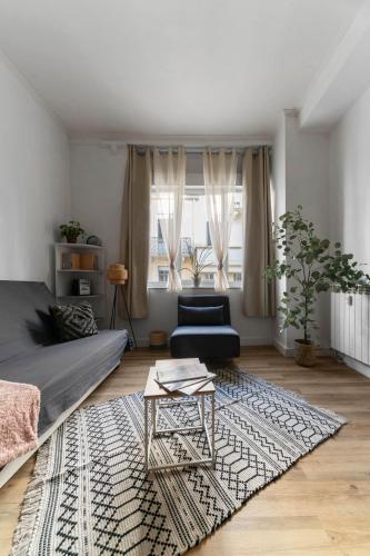 a living room with a couch and a table at Le Clémenceau - Appartement design en centre ville in Vichy