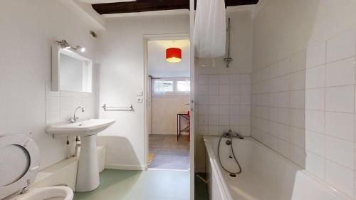 une salle de bain avec toilettes, lavabo et baignoire dans l'établissement Appartement entier proche gare avec parking, à Besançon