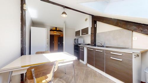 une cuisine avec une table et des chaises dans une pièce dans l'établissement Appartement entier proche gare avec parking, à Besançon