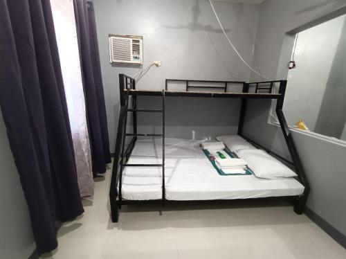 a black bunk bed with white sheets and pillows at Spy Balay 2x Homestay in Butuan