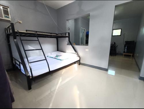 a bedroom with a bunk bed with a ladder at Spy Balay 2x Homestay in Butuan