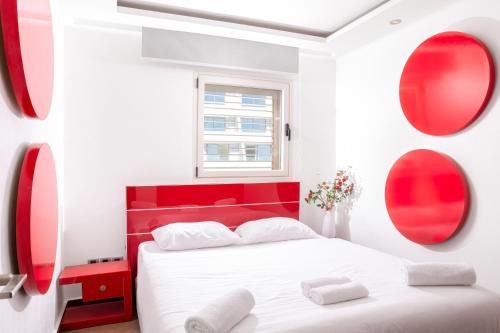 a red and white bedroom with a bed and two mirrors at פנטהאוז מול הים in Eilat