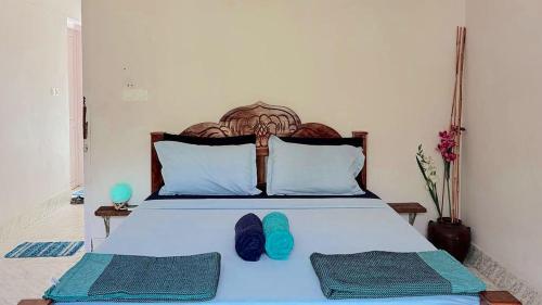 a bedroom with a bed with blue shoes on it at Villa Blue Sophy in Varkala