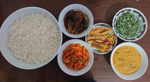 a table topped with bowls of different types of food at Didula Holiday Resort Anuradhapura in Anuradhapura