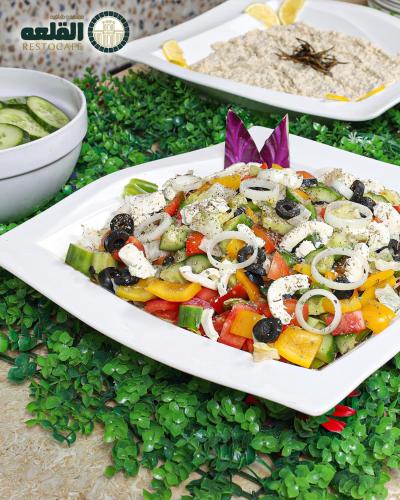 a white plate of food on a table with vegetables at Alqalah Restotel فندق ومطعم القلعة in Kerak