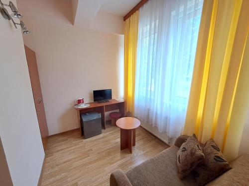 a living room with a couch and a desk with a computer at Penzion Zornicka in Bardejovské Kúpele