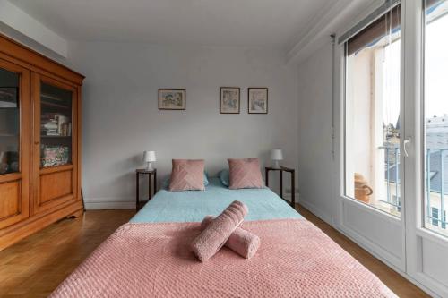 - une chambre avec un lit et 2 serviettes roses dans l'établissement Le Roosevelt - Appartement confort hyper centre - Idéal Curiste, à Vichy