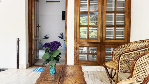 a vase of flowers on a table in front of a door at Villa Blue Sophy in Varkala