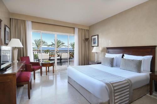 a hotel room with a bed and a balcony at JAZ Dahabeya in Dahab