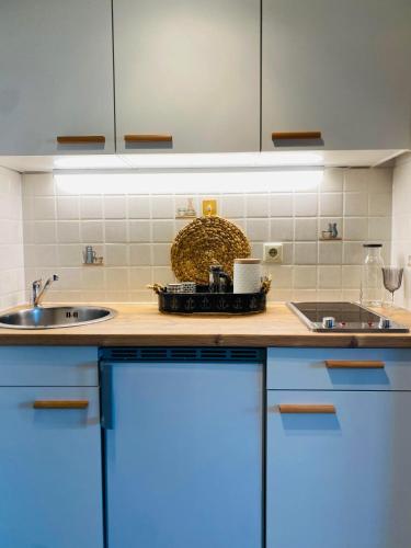 a kitchen with blue cabinets and a sink at Ferienwohnung Meernähe in Fehmarn