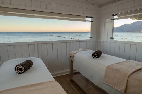 two beds in a room with a view of the ocean at JAZ Dahabeya in Dahab
