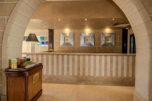 a lobby with a bar with pictures on the wall at JAZ Dahabeya in Dahab