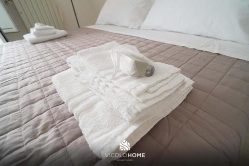 a white towel on a bed with a bag on it at Vicolo Home in Putignano