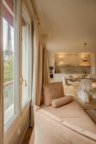 Apartment with Eiffel Tower view في باريس: غرفة معيشة بها أريكة ونافذة تطل على برج إيفل