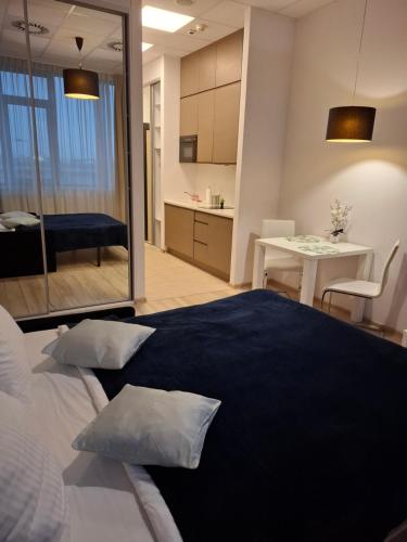 a bedroom with a bed and a kitchen and a table at Zlatarooms in Warsaw