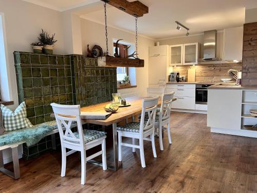 Una cocina y un comedor con mesa y sillas de madera. en Ferienhaus EulenNest, en Seeboden