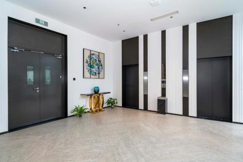 an empty lobby with black doors and a statue at Suzhou Qingfeng Mingyue Hotel in Yinshanhunongchang