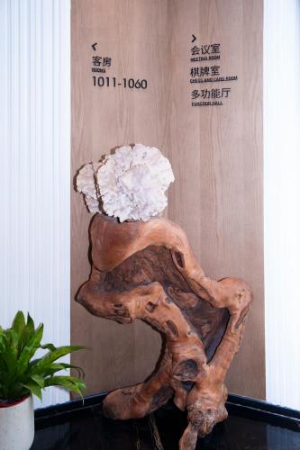 arified wood vase with a white flower on it at Suzhou Qingfeng Mingyue Hotel in Yinshanhunongchang