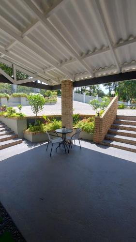 a patio with a table and chairs under a pavilion at Lodge Azure in Port Edward