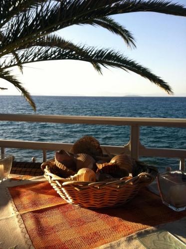 a basket of shells sitting on a table next to the ocean at Manthos Sea View in Kalloni