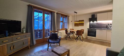 a living room with a kitchen and a table with chairs at Chalet am Bluemewäg 7 in Wengen