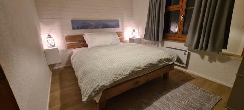 a small bed in a small bedroom with two lamps at Chalet am Bluemewäg 7 in Wengen