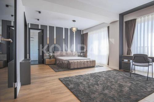 a bedroom with a bed and a table and a chair at Presidental Suite in Luxury Hotel at City Center in Pristina