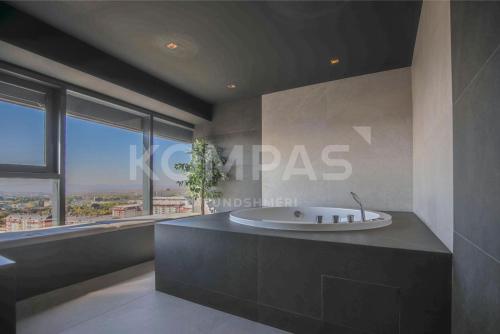 a bathroom with a bath tub with a large window at Presidental Suite in Luxury Hotel at City Center in Pristina