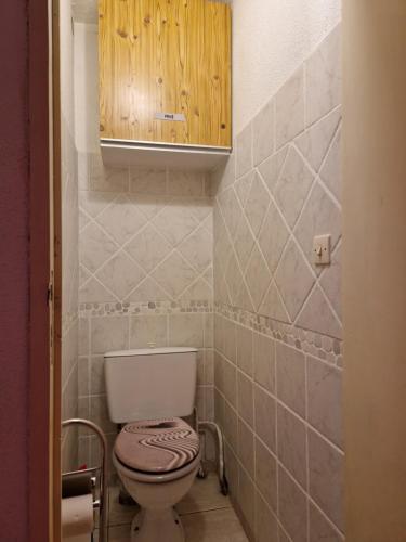 La salle de bains est pourvue de toilettes et d'une armoire en bois. dans l'établissement Villa lumineuse dans pinède calme et reposante location du dimanche au dimanche, au Cap d'Agde