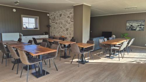 a dining room with wooden tables and chairs at B&B De Dulle Koe in Waregem