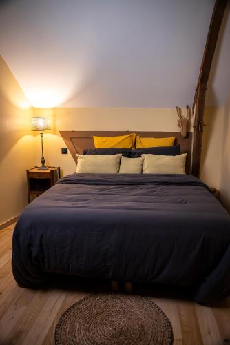 a bedroom with a large bed with a blue comforter at Dépendance maison bourgeoise in Grand-Fougeray