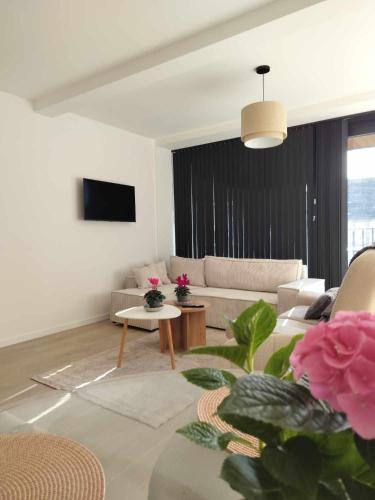 a living room with a couch and a table at Sealor, zonnig appartement met ruim terras in De Panne