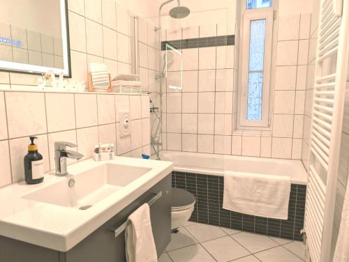a bathroom with a sink and a toilet and a tub at 5 Personen, familienfreundlich, Waschmaschine, Balkon, Amazon Prime in Magdeburg