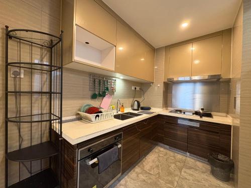 Una cocina con gabinetes de madera y un fregadero. en R&F Princess Cove Boutique Homestay By TREX #Nearby CIQ #Johor Bahru #JB Central #To custom 10minit, en Johor Bahru