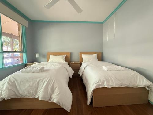 two beds sitting next to each other in a bedroom at Hawker 4BR House in Canberra