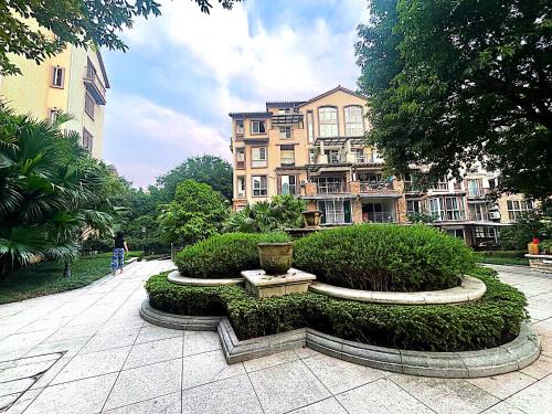 a park with bushes and a building in the background at 哲帆民宿花园洋房江与城店 in Chongqing