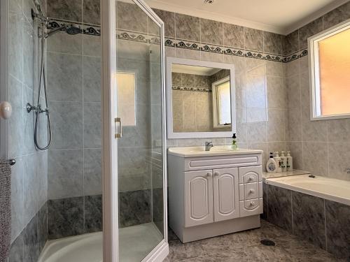 a bathroom with a shower and a sink and a tub at Hawker 4BR House in Canberra