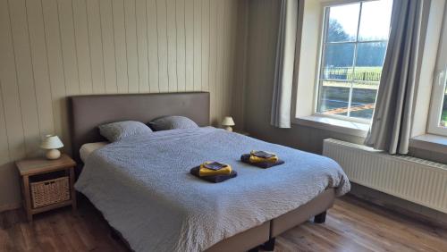 a bedroom with a bed with two towels on it at B&B De Dulle Koe in Waregem