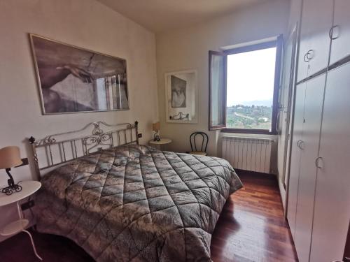 a bedroom with a bed and a large window at Mezzomonte View in Impruneta