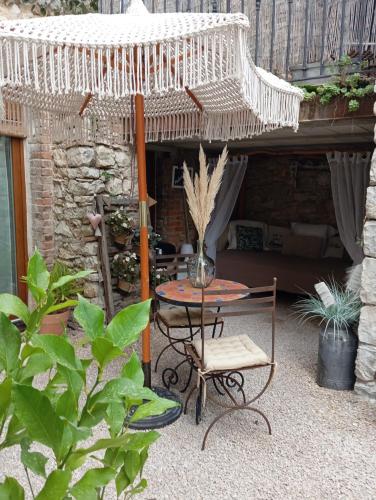 un patio avec un parasol, une table et des chaises dans l'établissement Le MasDinina Superbe studio entièrement rénové, à Seynes