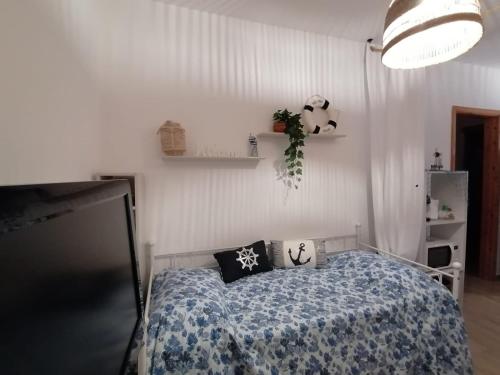 a bedroom with a bed with a blue and white comforter at Villa Mykonos in Fontane Bianche