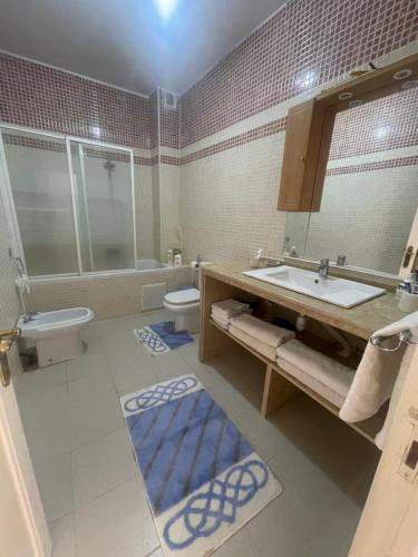 a bathroom with a sink and a toilet and a mirror at Villa Saidia in Saidia 