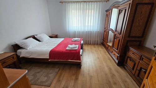 una camera da letto con un letto con una coperta rossa di Casa Dacian 1 a Oradea