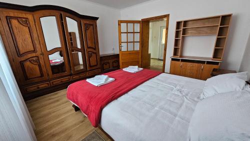 una camera da letto con un letto grande con una coperta rossa di Casa Dacian 1 a Oradea