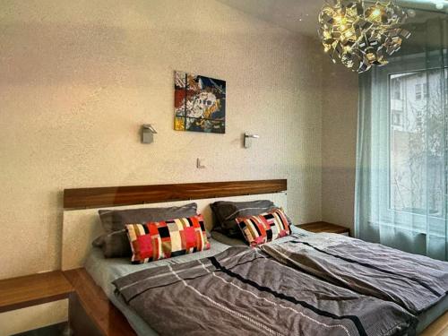 a bedroom with a bed with pillows and a chandelier at AAM Ferienwohnung 75qm Saarlouis citynah PP WiFi in Saarlouis